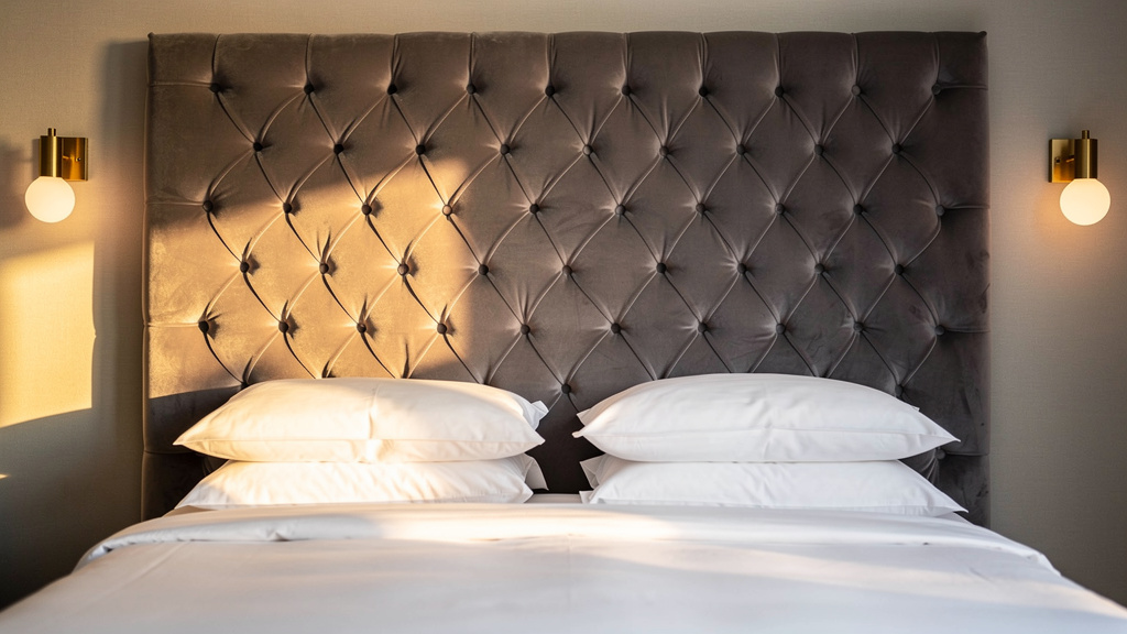 Custom deep-buttoned velvet headboard showcasing specialist upholstery techniques