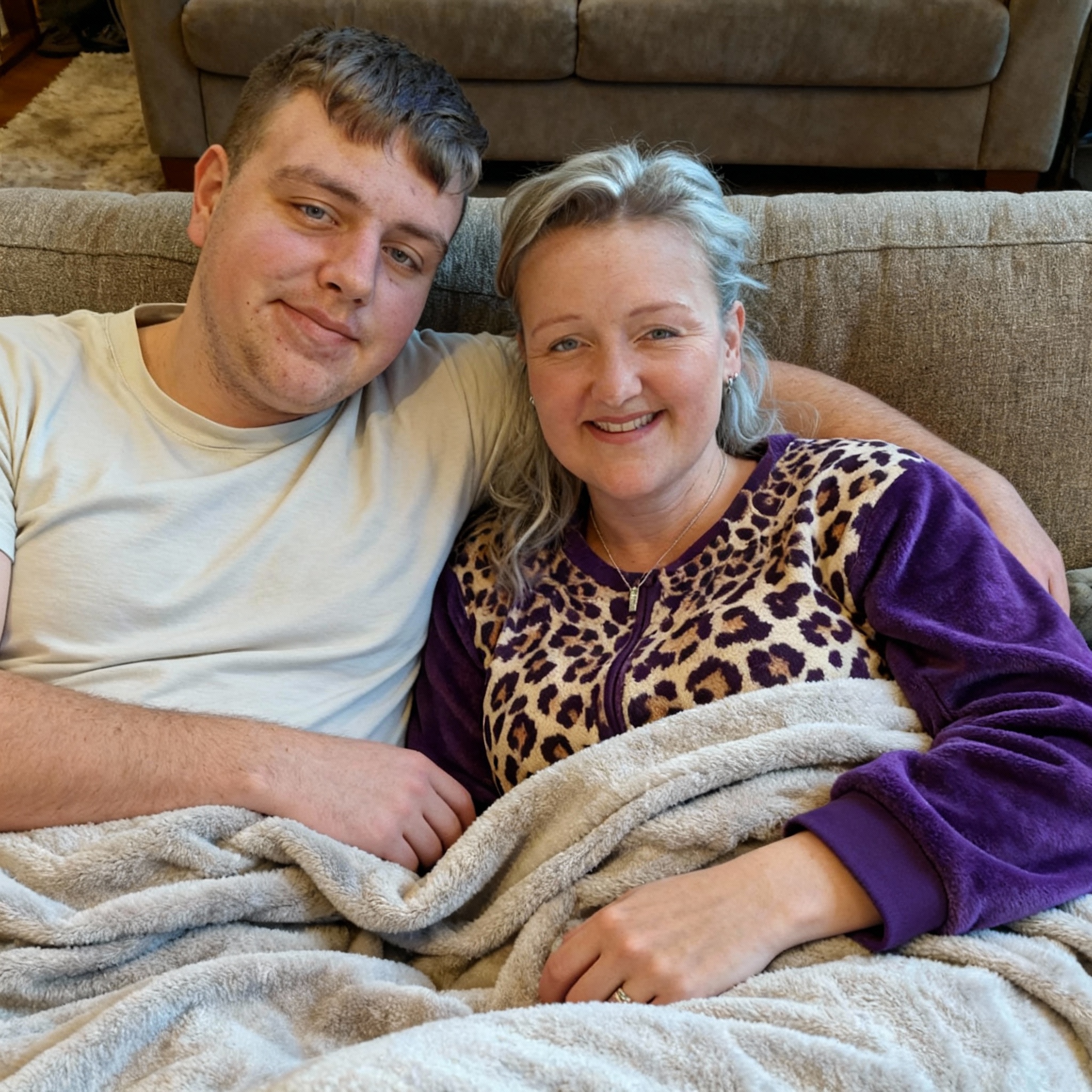 samen-op-de-bank-onder-deken-in-huispak-als-een-afkyyh69m8