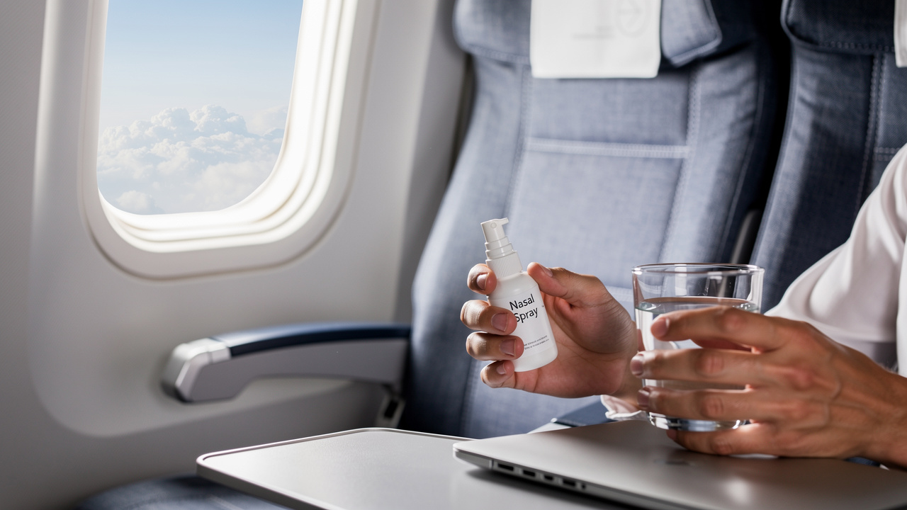 Traveler using nasal spray during flight