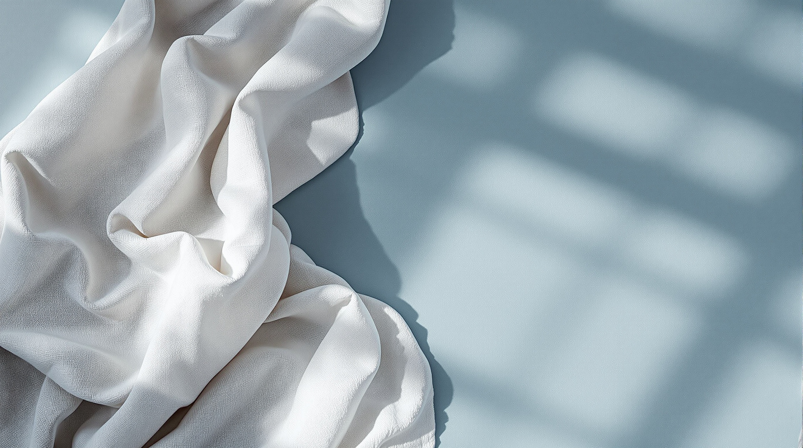 raw-linen-fabric-gently-folded-on-muted-blue-rs2lsjjuyl