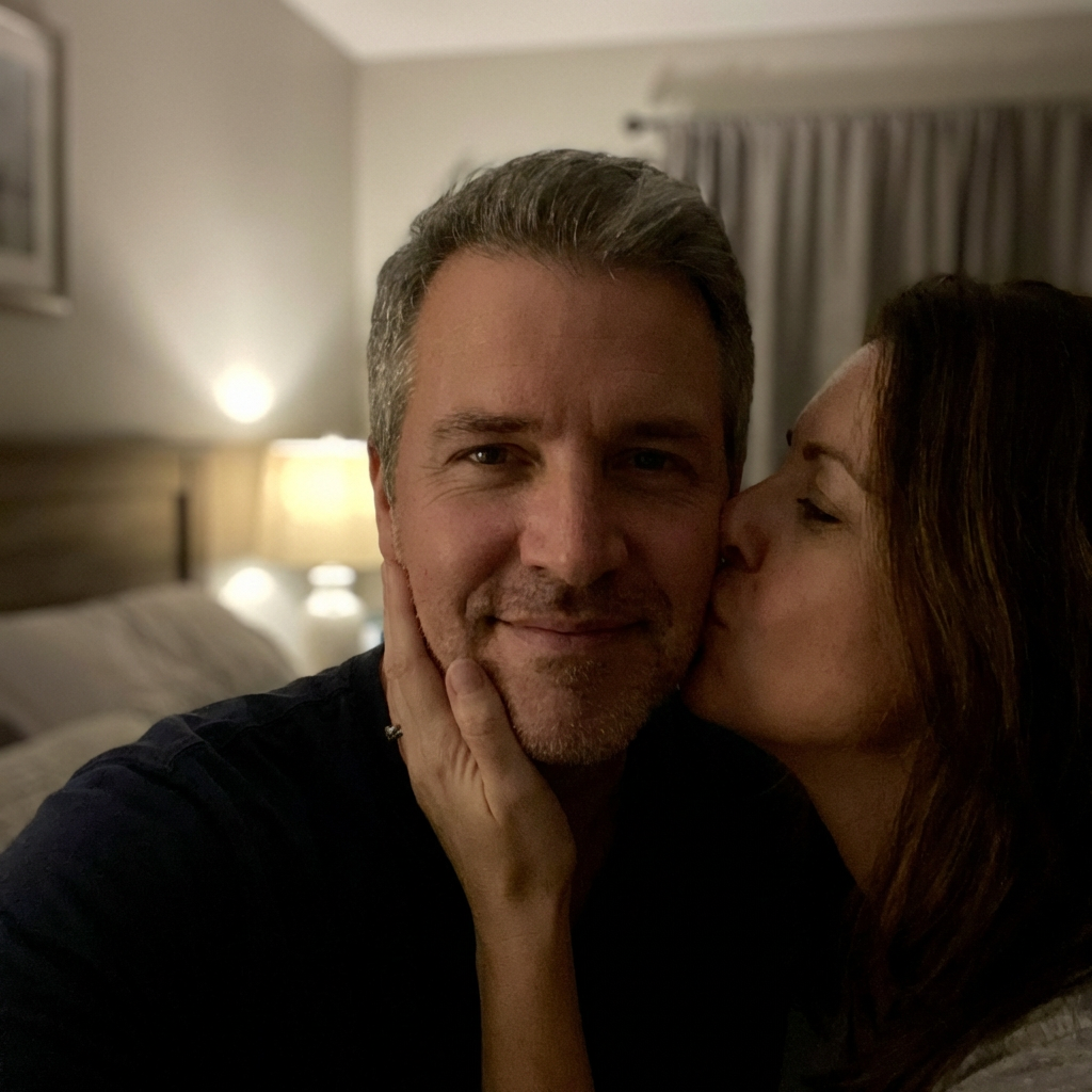 Couple kissing goodnight in dimly lit bedroom, tender moment