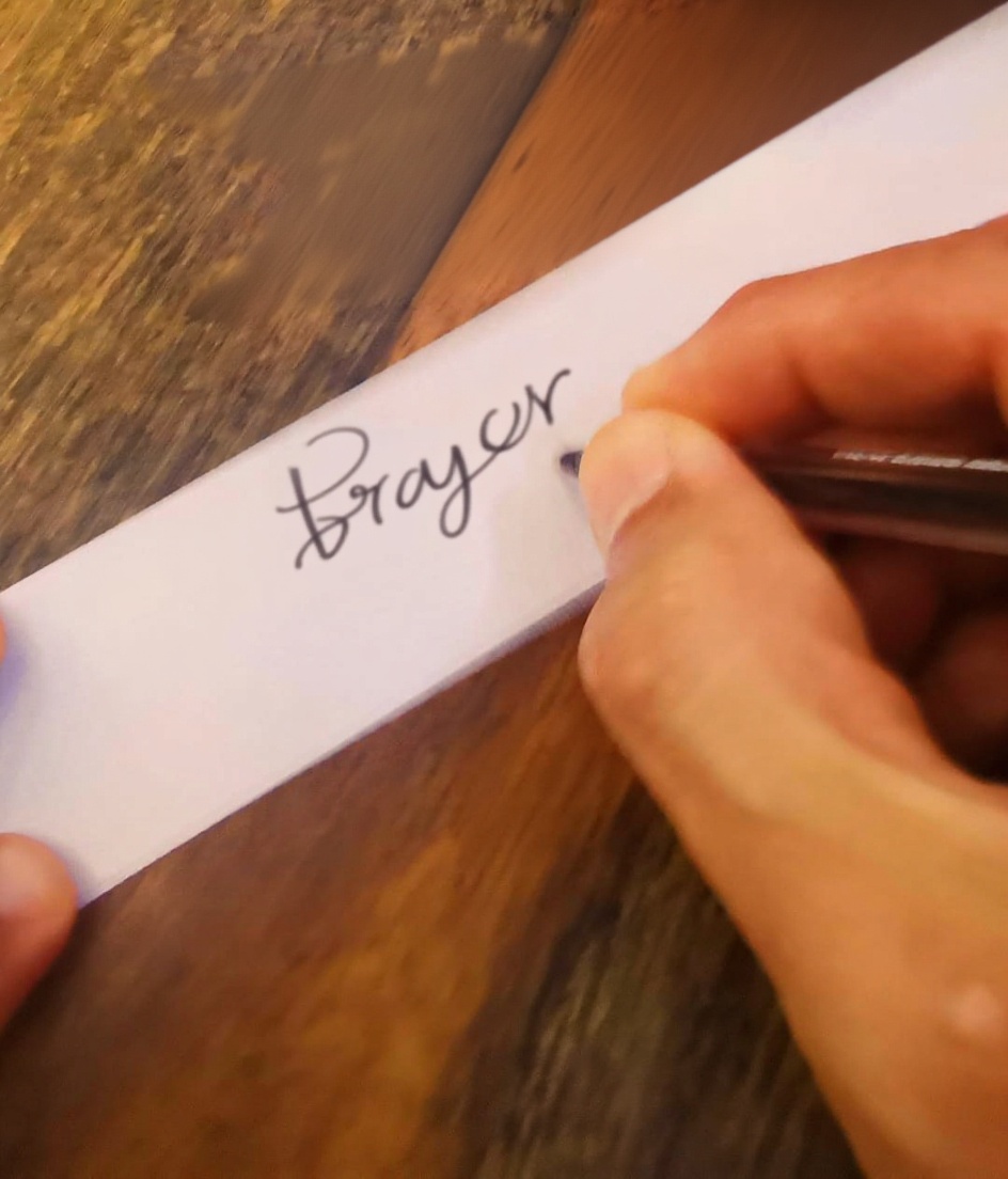 calm-hands-writing-a-prayer-on-a-white-ribbon-warm-x0vwhnn41