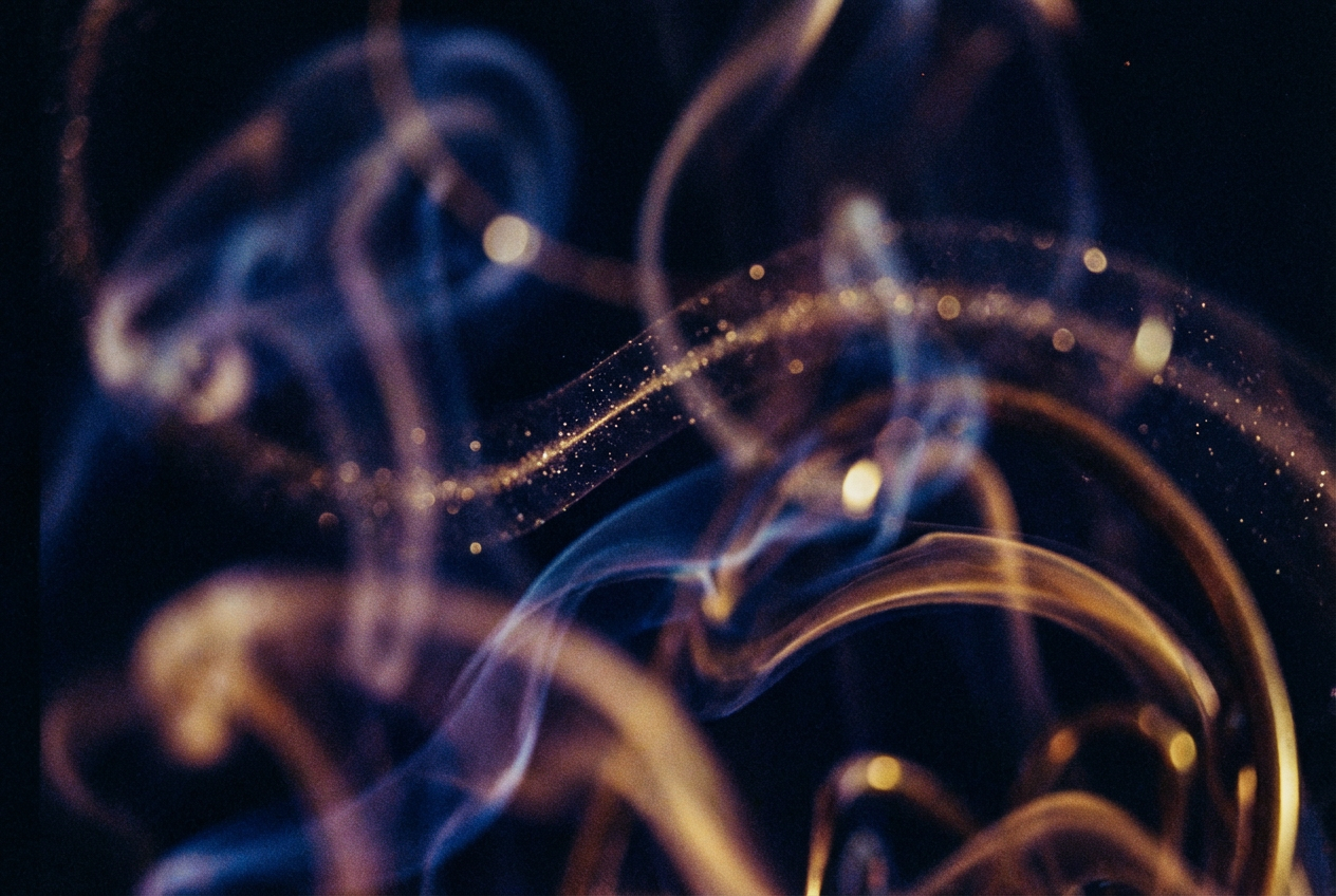 Swirling abstract shapes in deep blues, purples, and gold tones, morphing organic forms resembling sound waves and saxophone curves, particles of light scattered like notes from an instrument, fluid motion trails suggesting musical improvisation, dark background