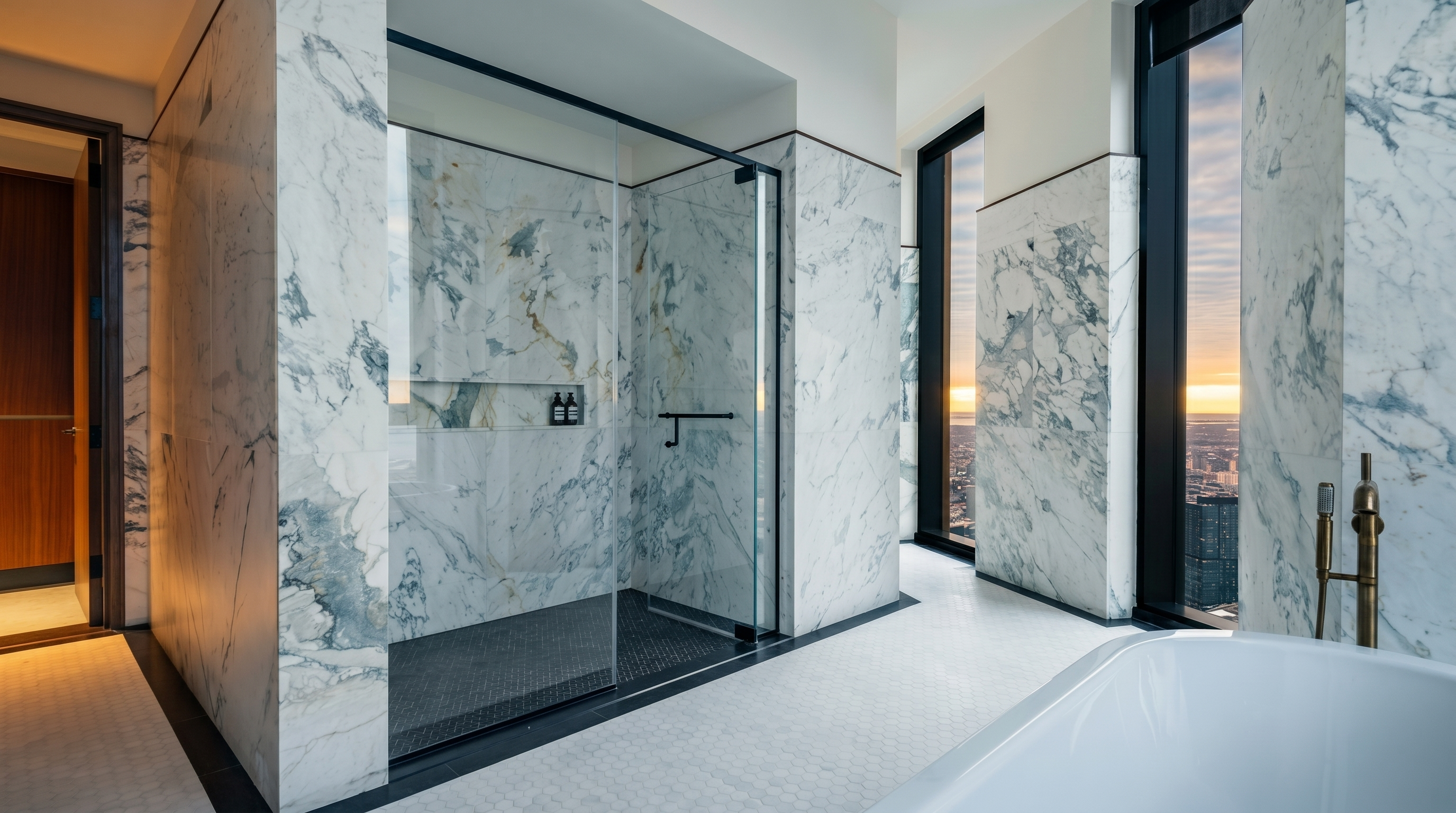 This luxurious primary bathroom features high-end marble wall cladding, a spacious walk-in glass shower with dark tile flooring, and a sleek freestanding soaking tub. Large floor-to-ceiling windows provide a breathtaking, elevated view of the city skyline at sunset, creating an atmosphere of sophisticated urban elegance. The minimalist design and premium materials emphasize a modern, spa-like retreat.