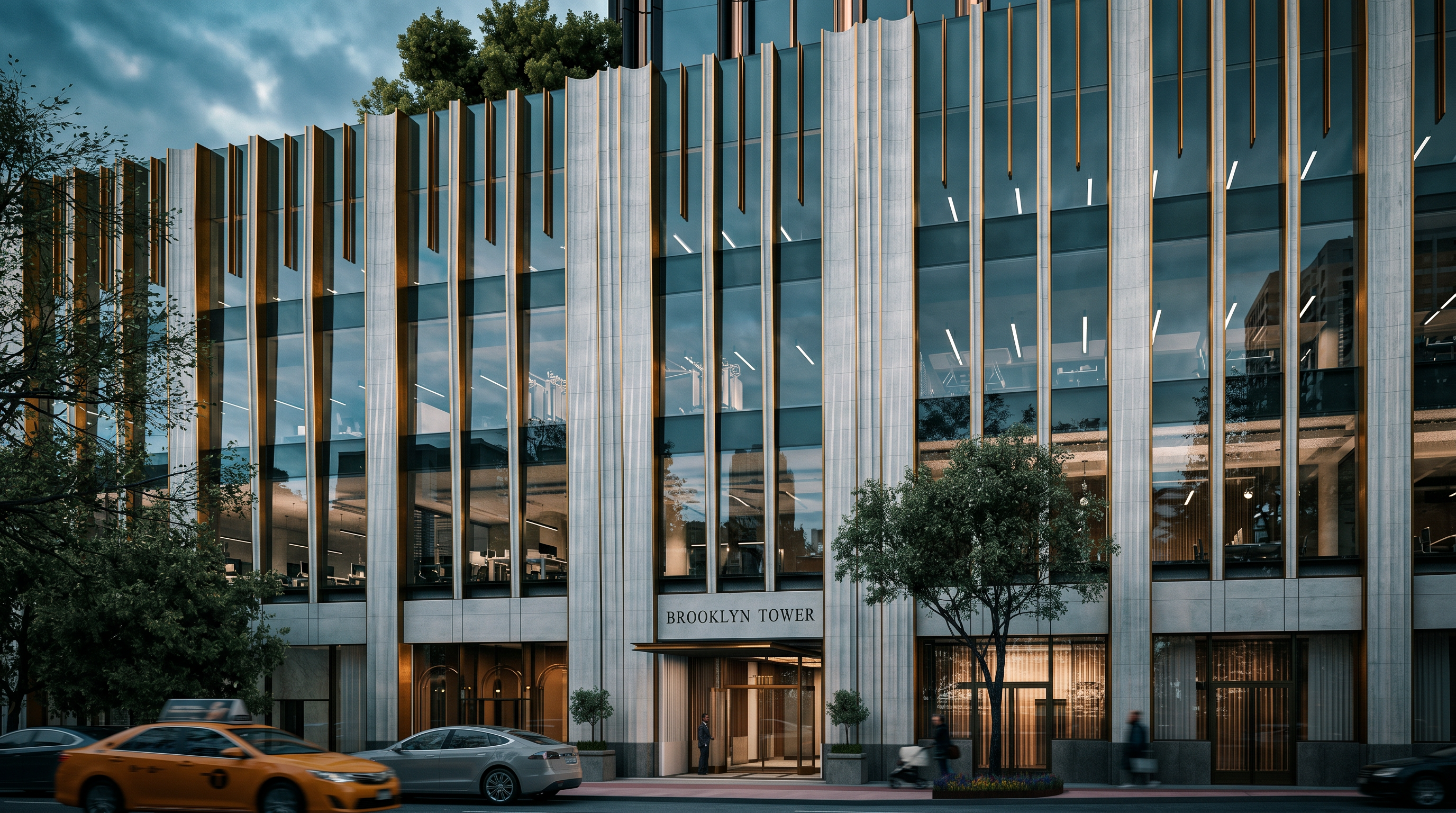 This image captures the sophisticated street-level entrance of the Brooklyn Tower, characterized by a striking Art Deco-inspired facade with vertical stone and metallic accents. The perspective is a ground-level street view, showcasing a modern glass-fronted lobby, a sleek canopy over the entrance, and manicured landscaping with a prominent tree. The overall impression is one of high-end urban luxury and architectural elegance.