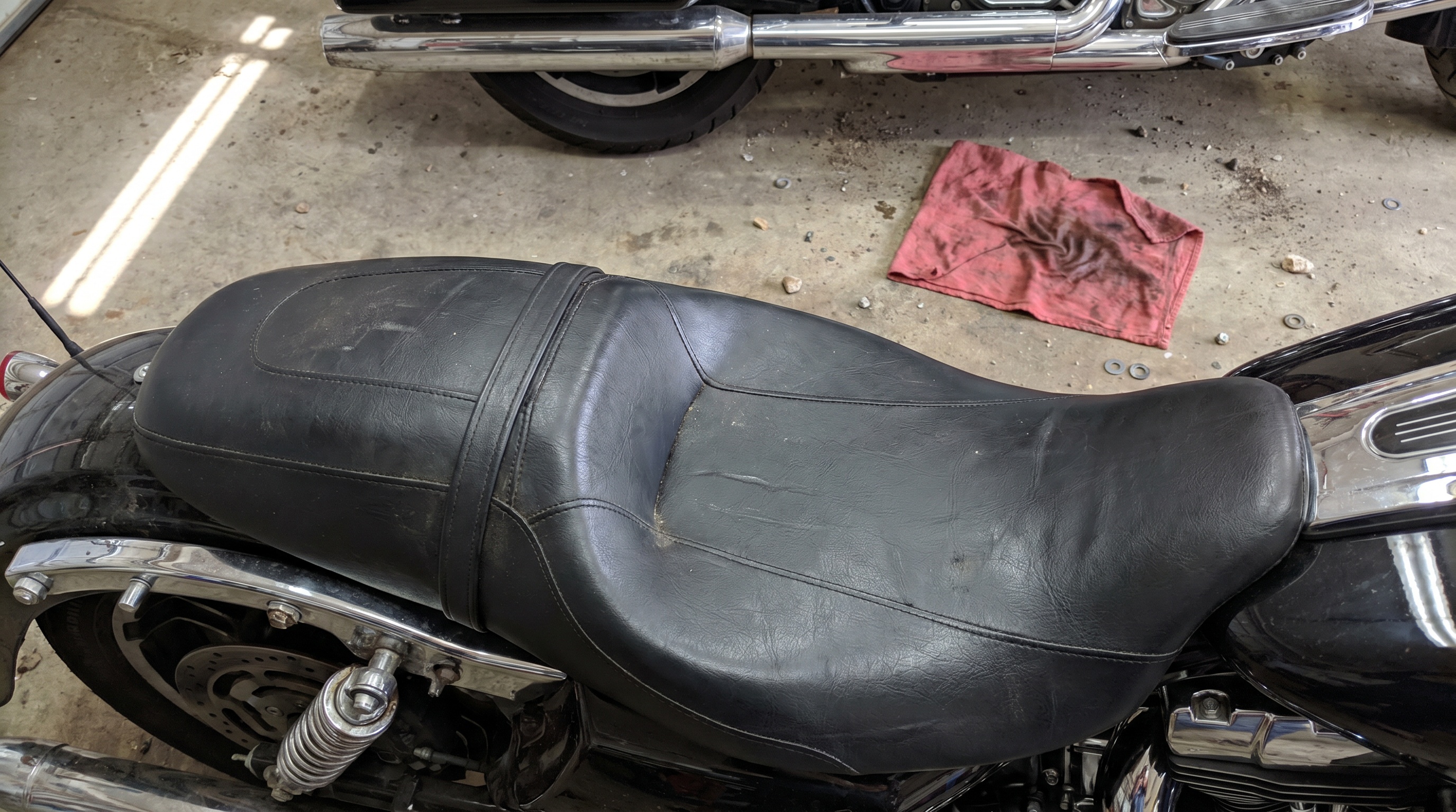Harley Street Glide seat surface showing compressed factory vinyl after months of garage storage before summer riding season