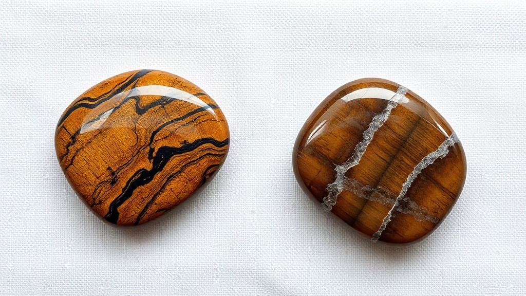 Side-by-side comparison of a genuine natural tiger eye stone and a glass imitation on a linen background