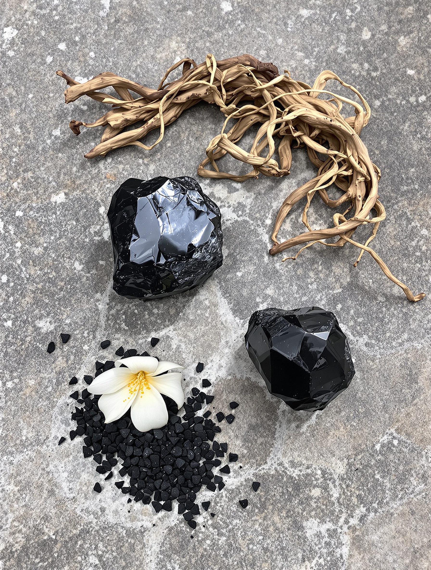 Raw obsidian, nagarmotha root, oud chips, and a jasmine bloom on plain stone distill the ingredient heart of 777 God of Fire.