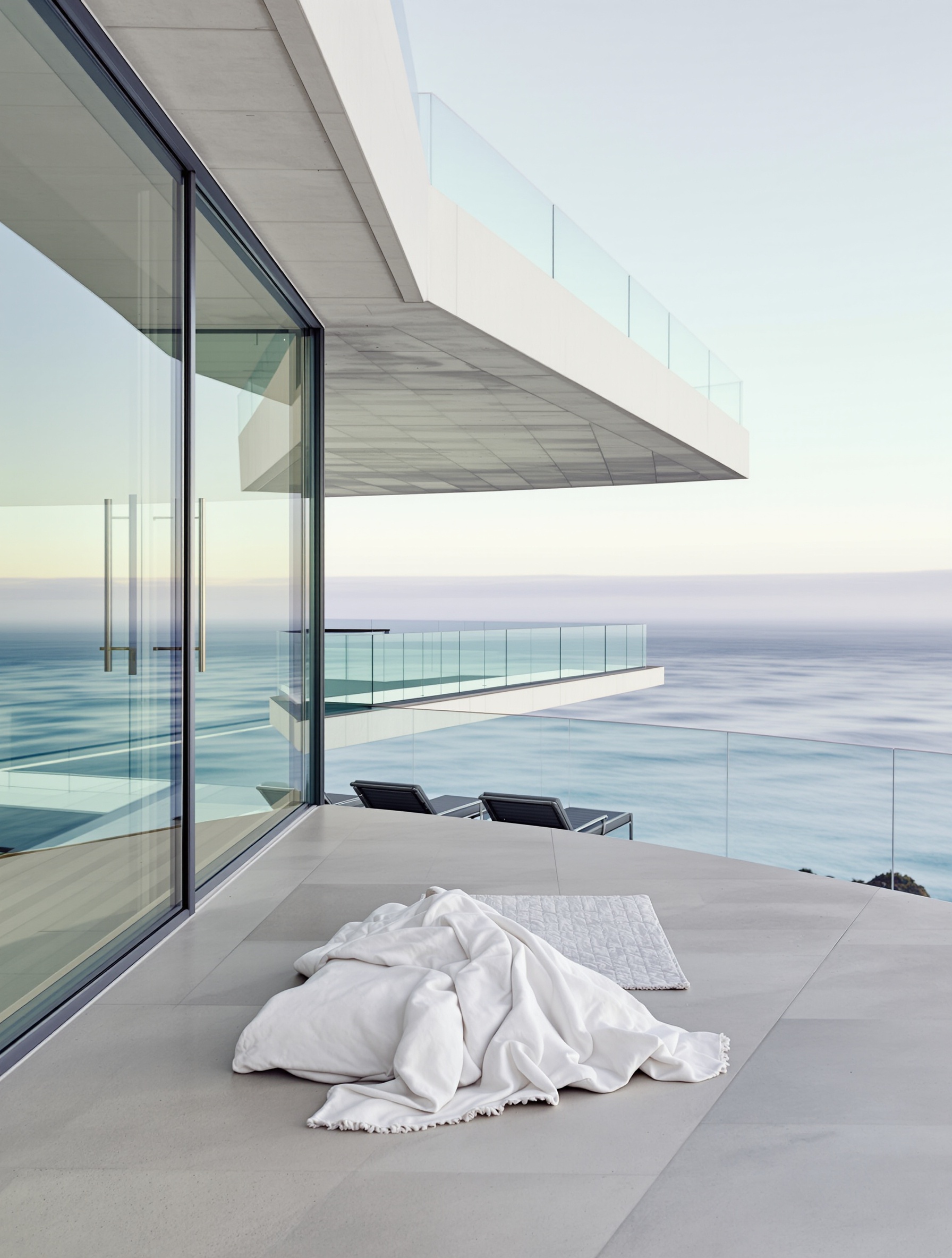 A cantilevered Malibu glass house at dawn above the Pacific marine layer, evoking the coastal morning world of Pacific Chill.