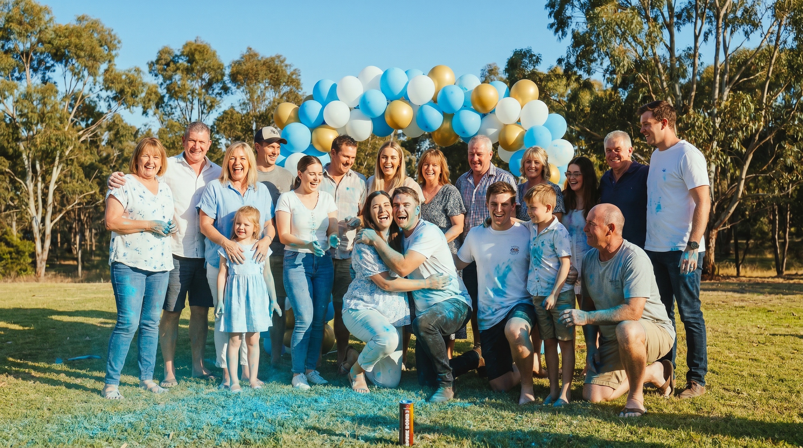 Australian family celebrating successful gender reveal with happy guests and coloured powder remnants in backyard