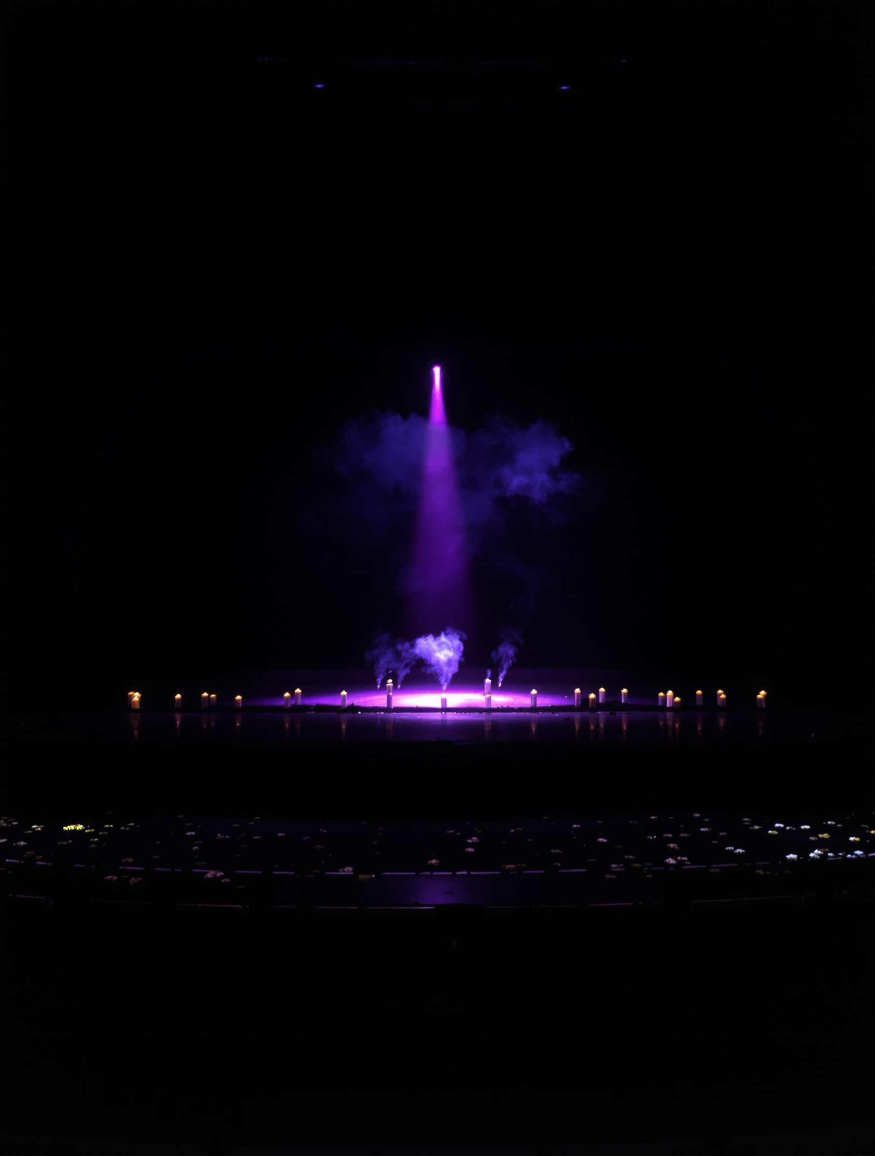 An empty stage after a performance, one violet spotlight illuminating rising candle smoke, evoking the sacred grief of Purple Rain Überblau.