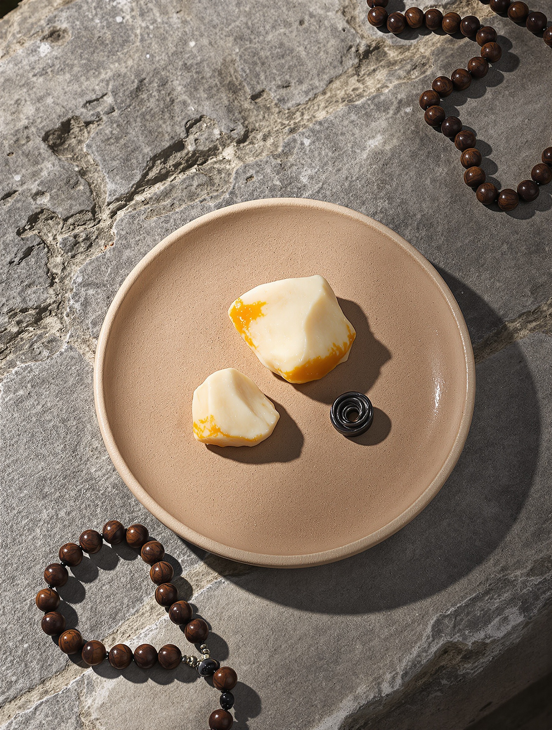 Raw ambergris and musk resin on stone with prayer beads, the material soul of Musc Khabib by Bortnikoff.