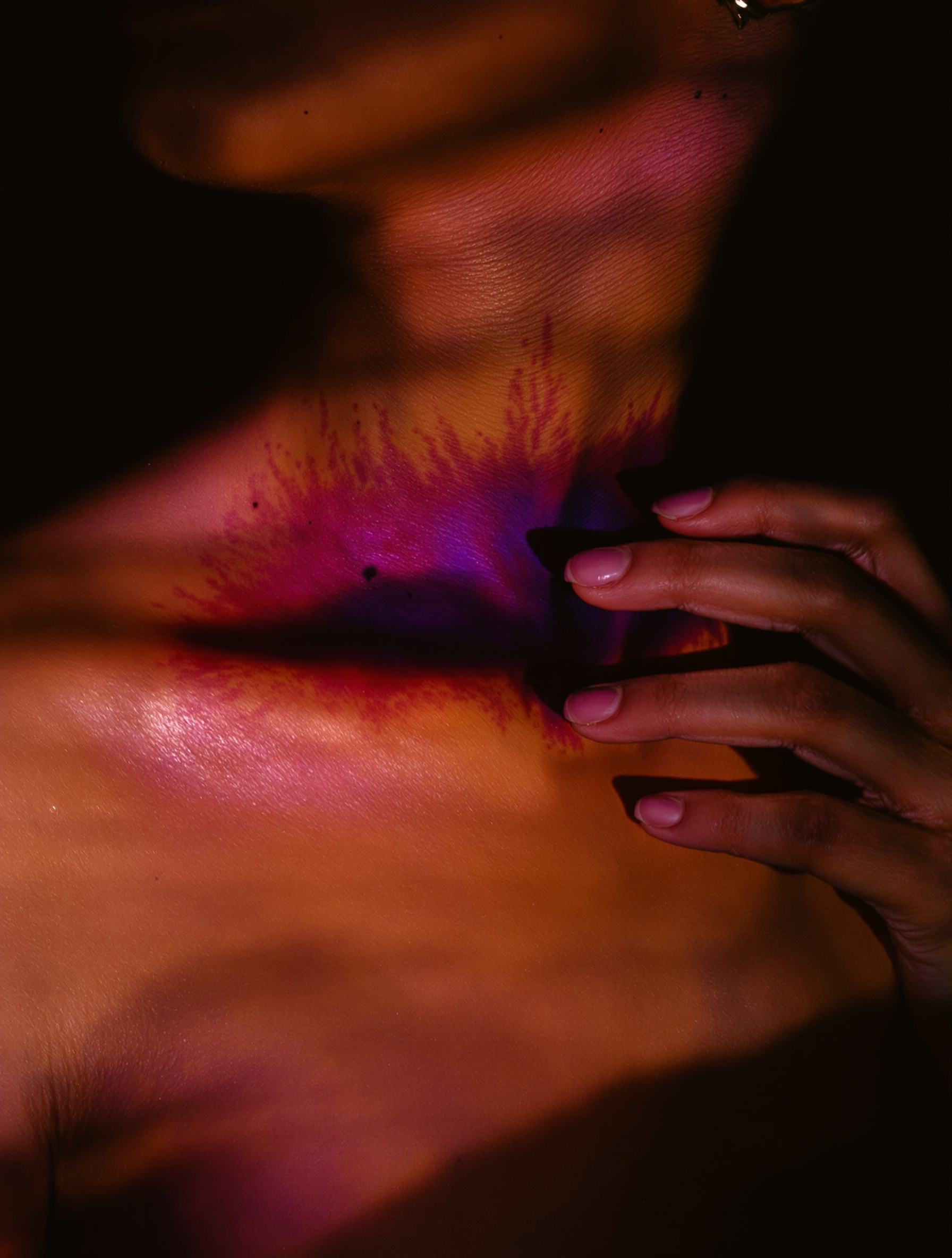 A bare-shouldered woman in close profile, eyes closed, skin lit amber from below by unseen embers, one hand resting at her own throat in a gesture of quiet, unapologetic possession.