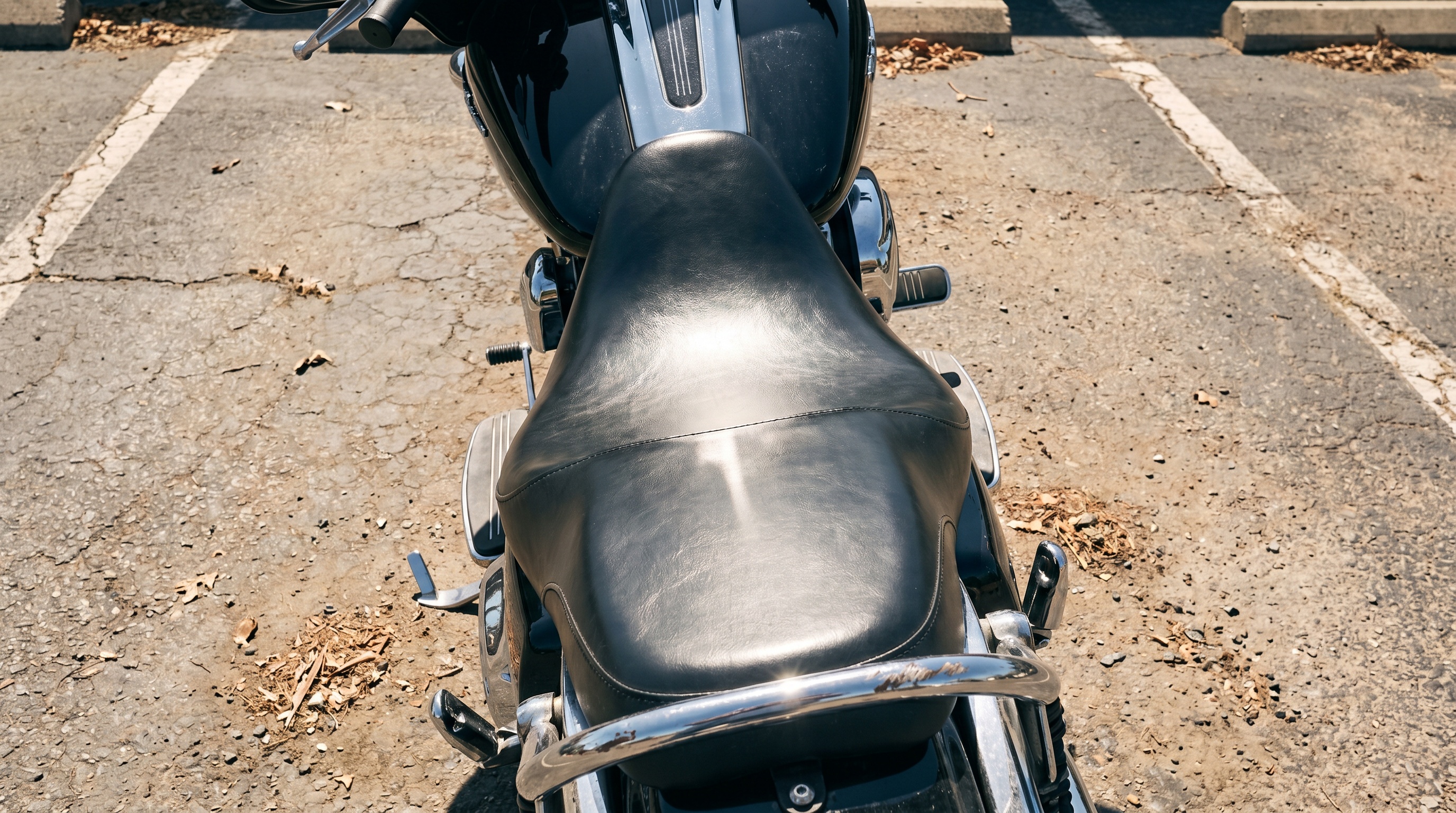 Close-up of a Harley Street Glide stock vinyl seat baking in direct afternoon sunlight, showing heat buildup