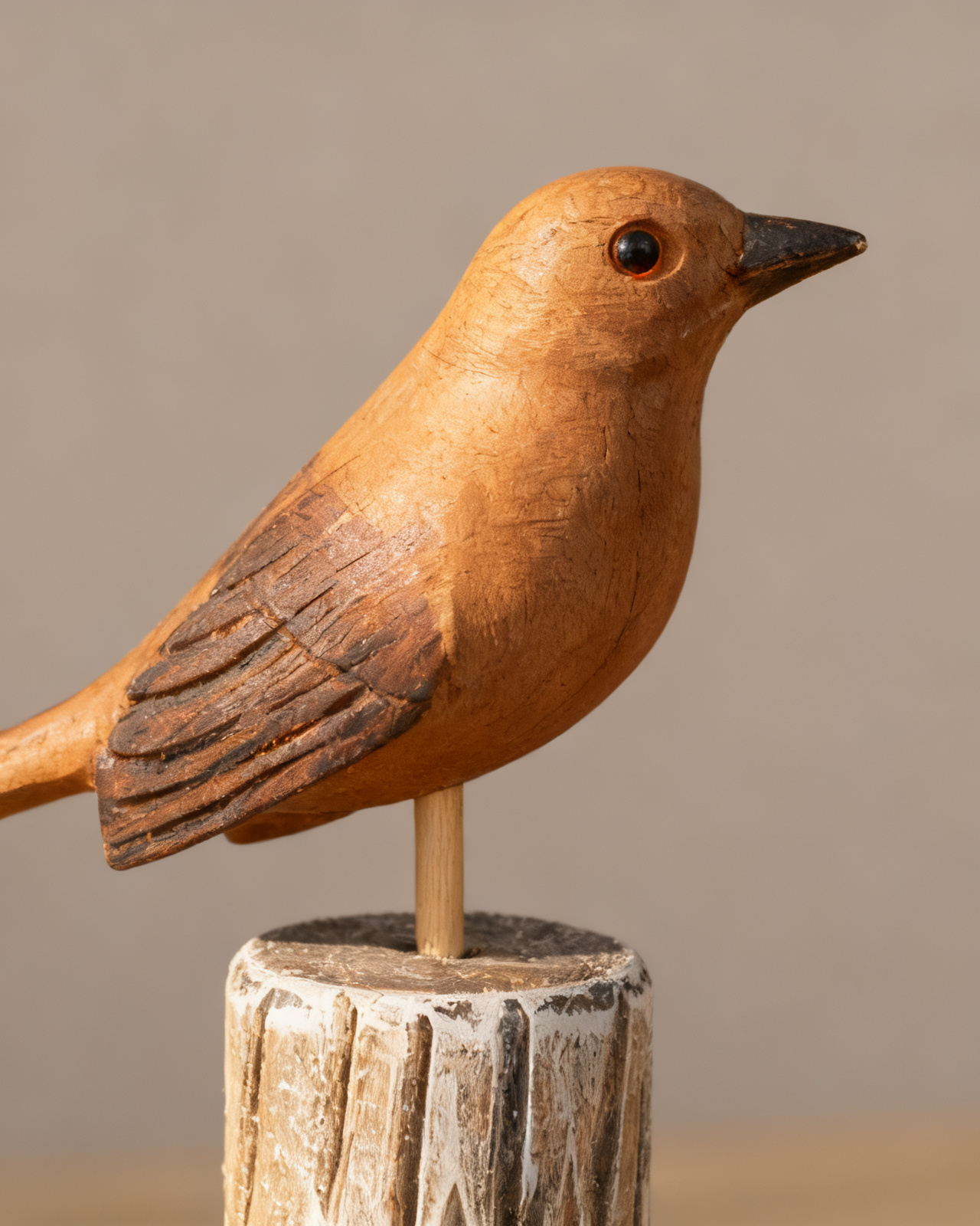 Macro of the bare carved wing — wood grain, gouge tool-marks and the small dark eye