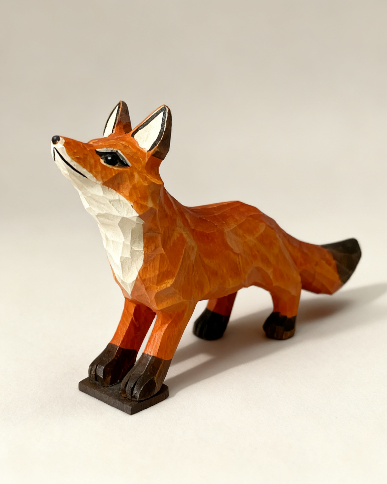 Hand-carved wooden fox standing alert with one paw lifted