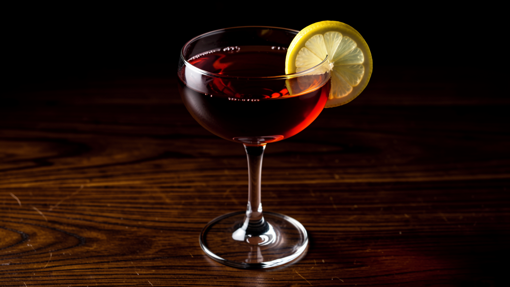 Bourbon Renewal in a coupe glass showing the deep garnet-purple color from bourbon, lemon juice, and crème de cassis