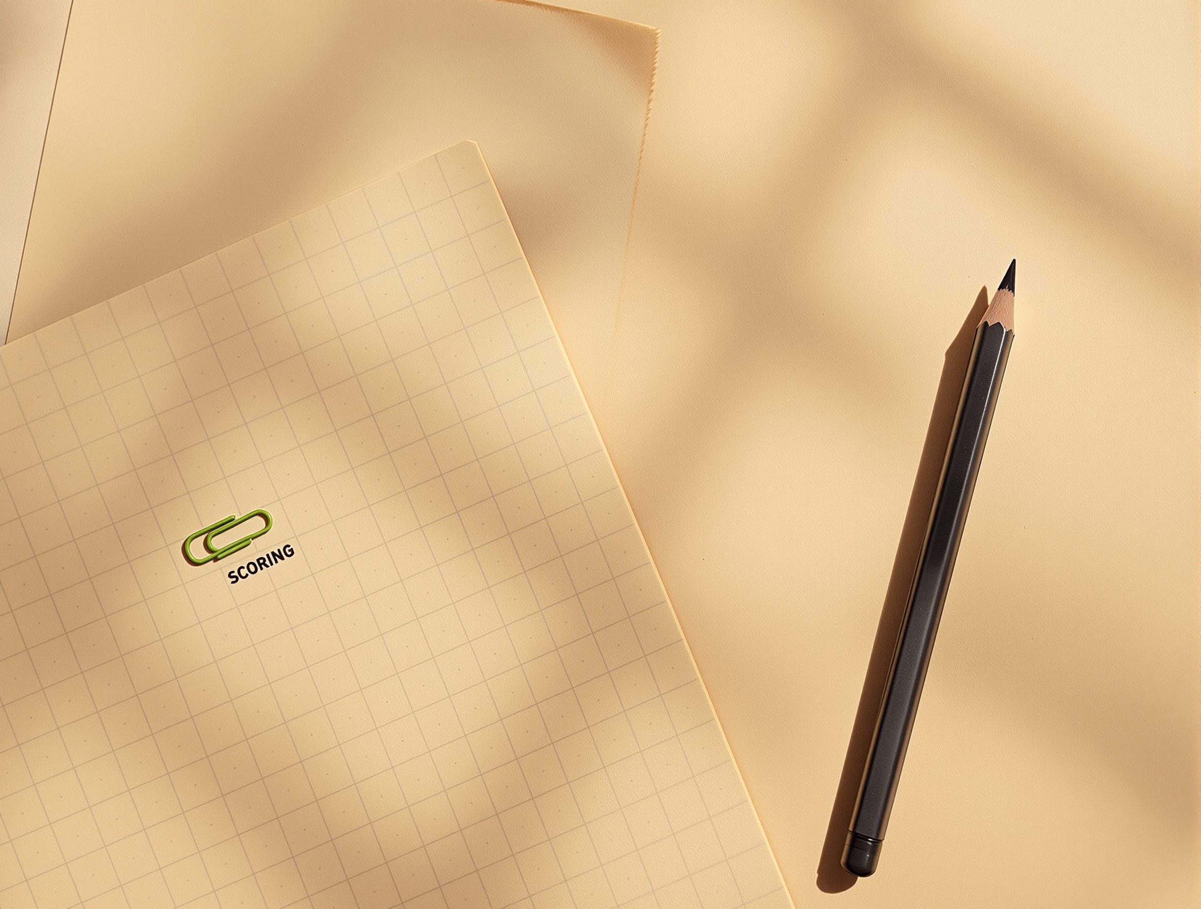Notepad with grid lines suggesting a scoring system on a desk.