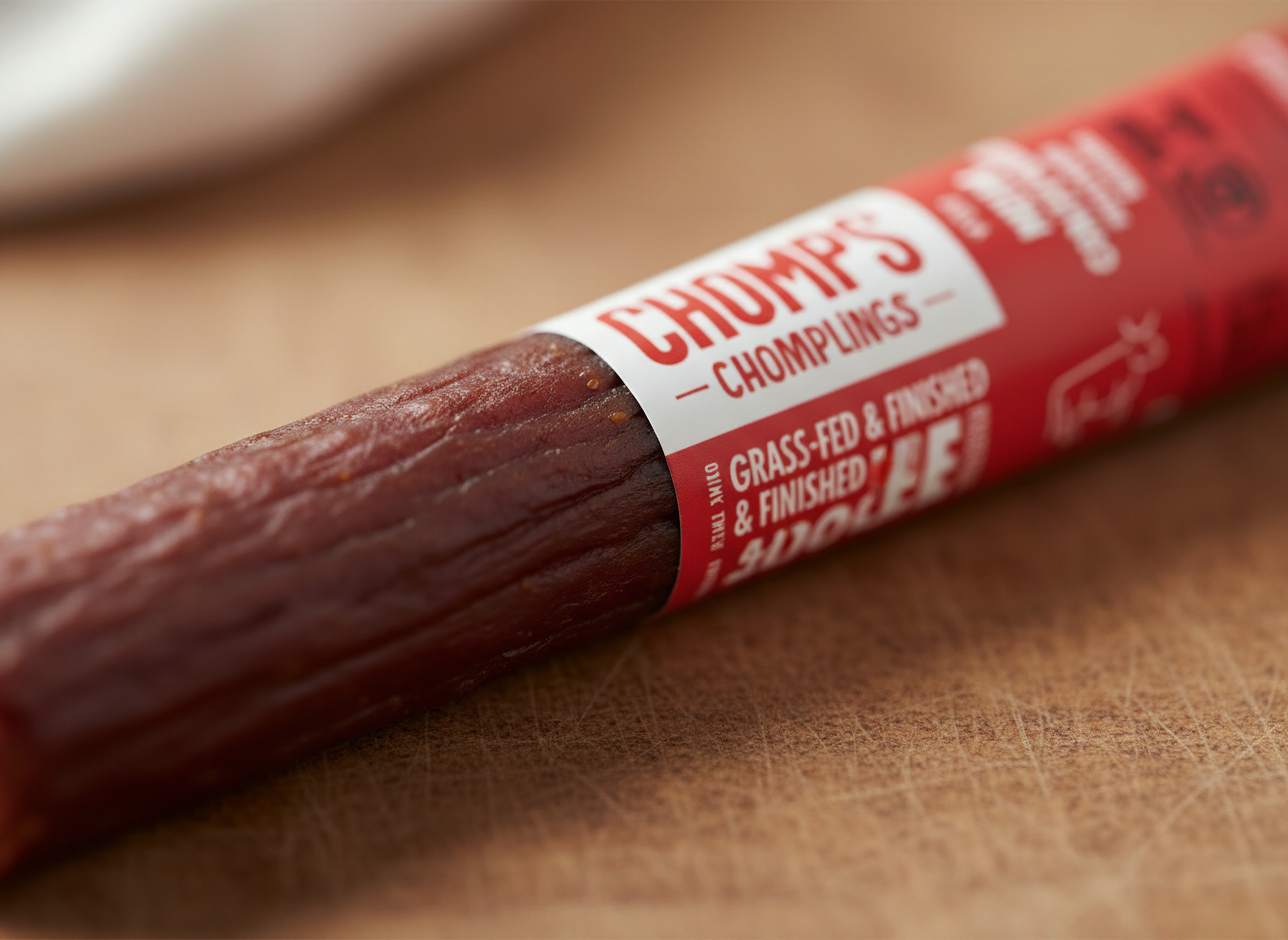 Macro close-up of Chomps beef jerky stick showing detailed meat texture and surface, shallow focus