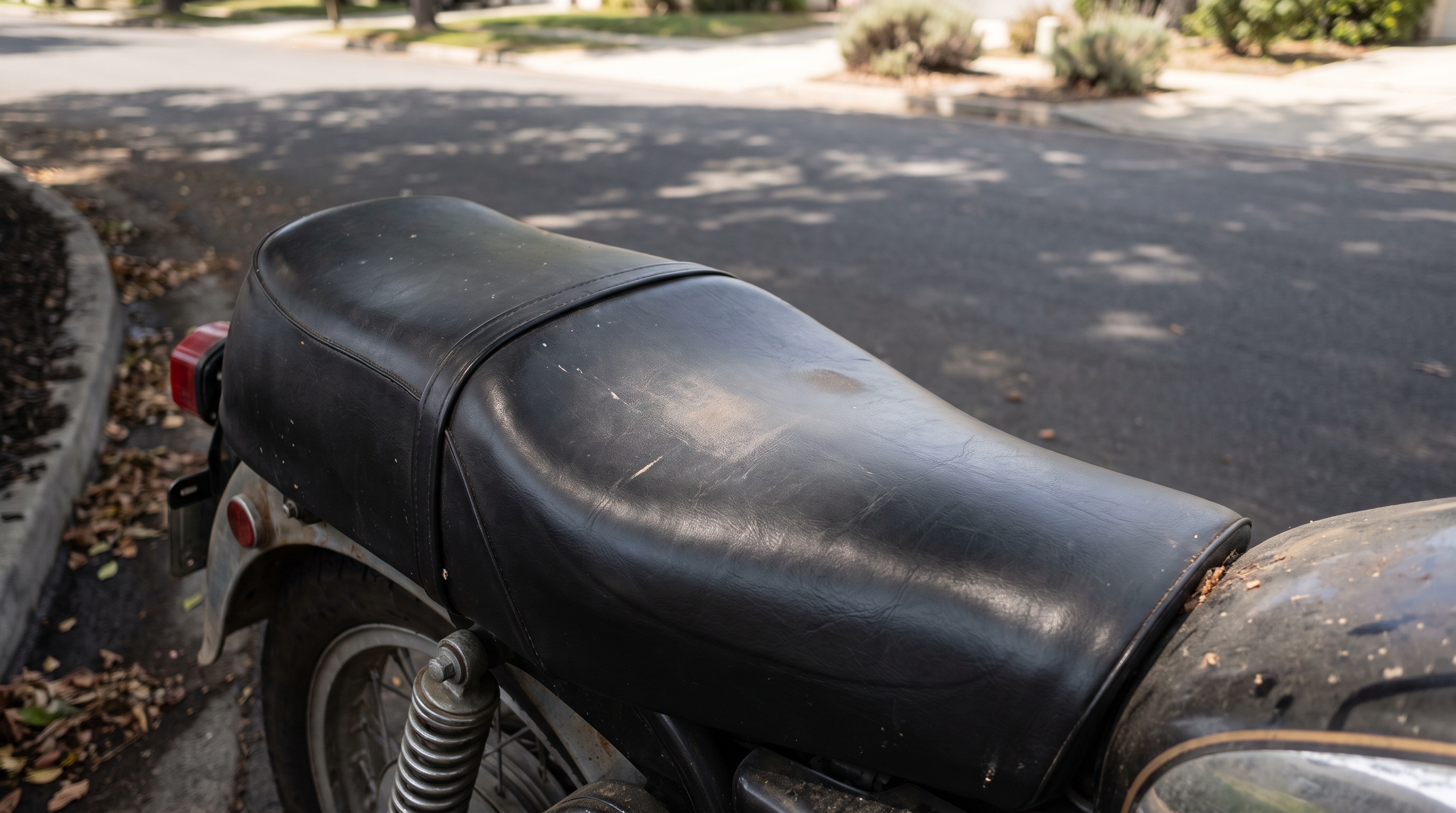 Close view of stock factory vinyl seat on a vintage Moto Guzzi cruiser in warm afternoon light