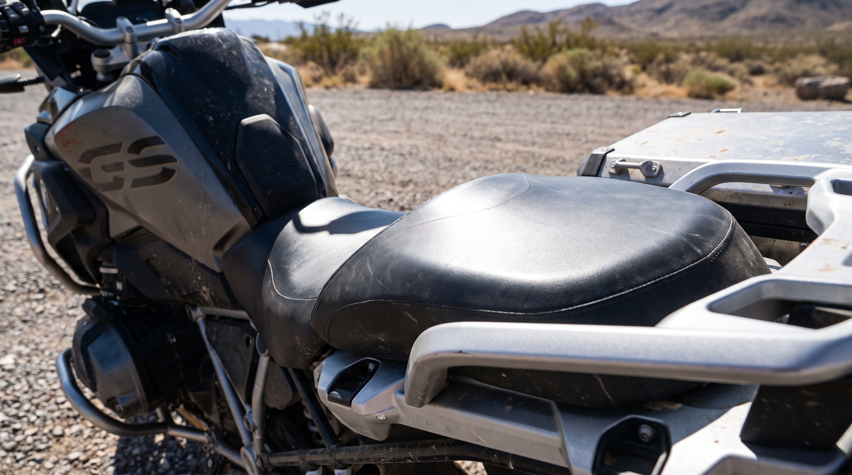 Close side view of bare black vinyl motorcycle seat heating up in direct sun showing how the surface traps heat
