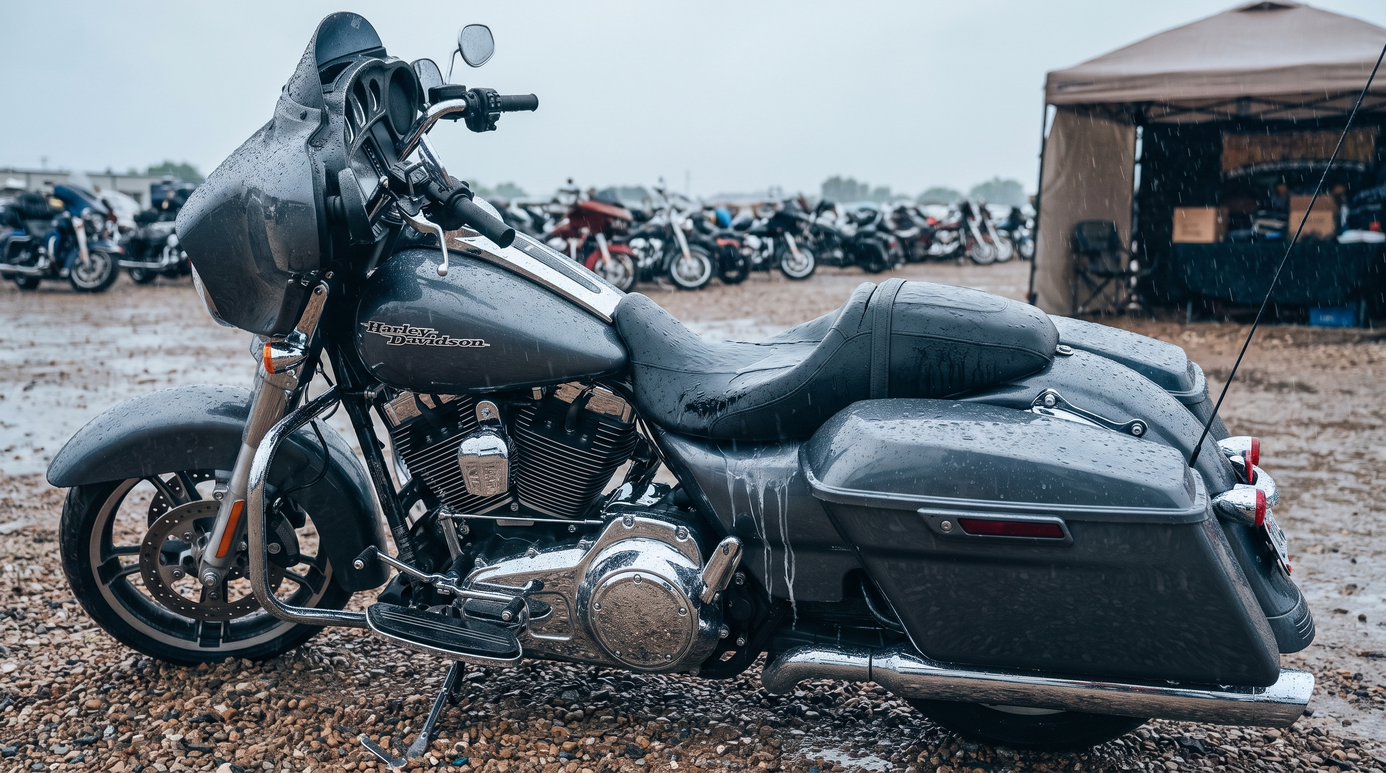 Rain pooling on a plain factory vinyl motorcycle seat at a rally parking area during a sudden storm