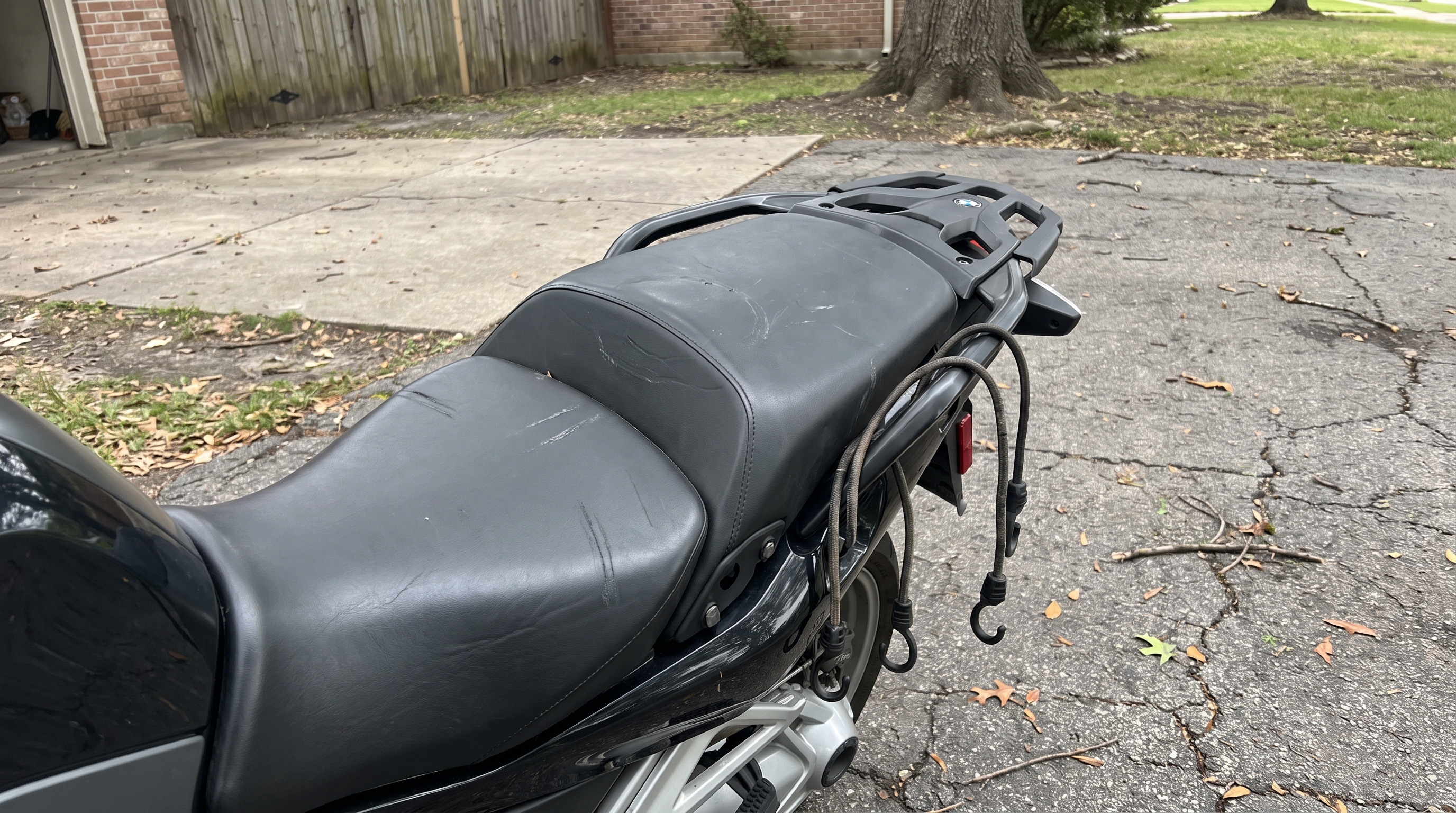 Empty rear passenger seat on a BMW R1250RT showing scuff marks from strapped luggage