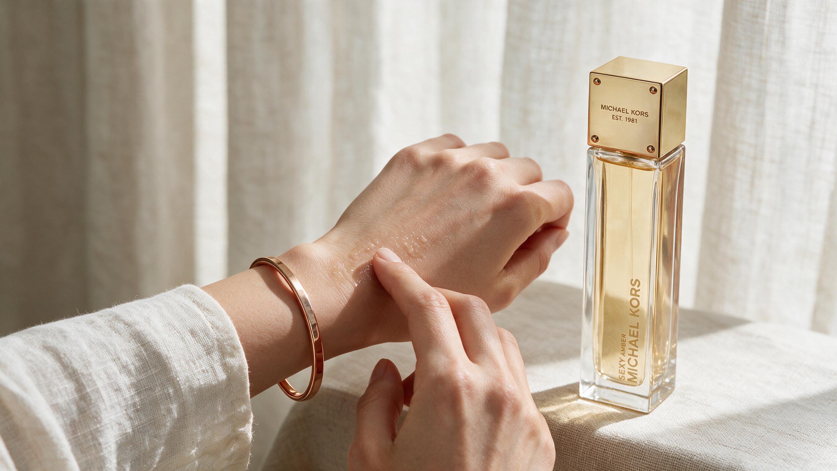 Close-up of a woman's wrist applying perfume with a bottle nearby, soft daylight, elegant and clean aesthetic, no text