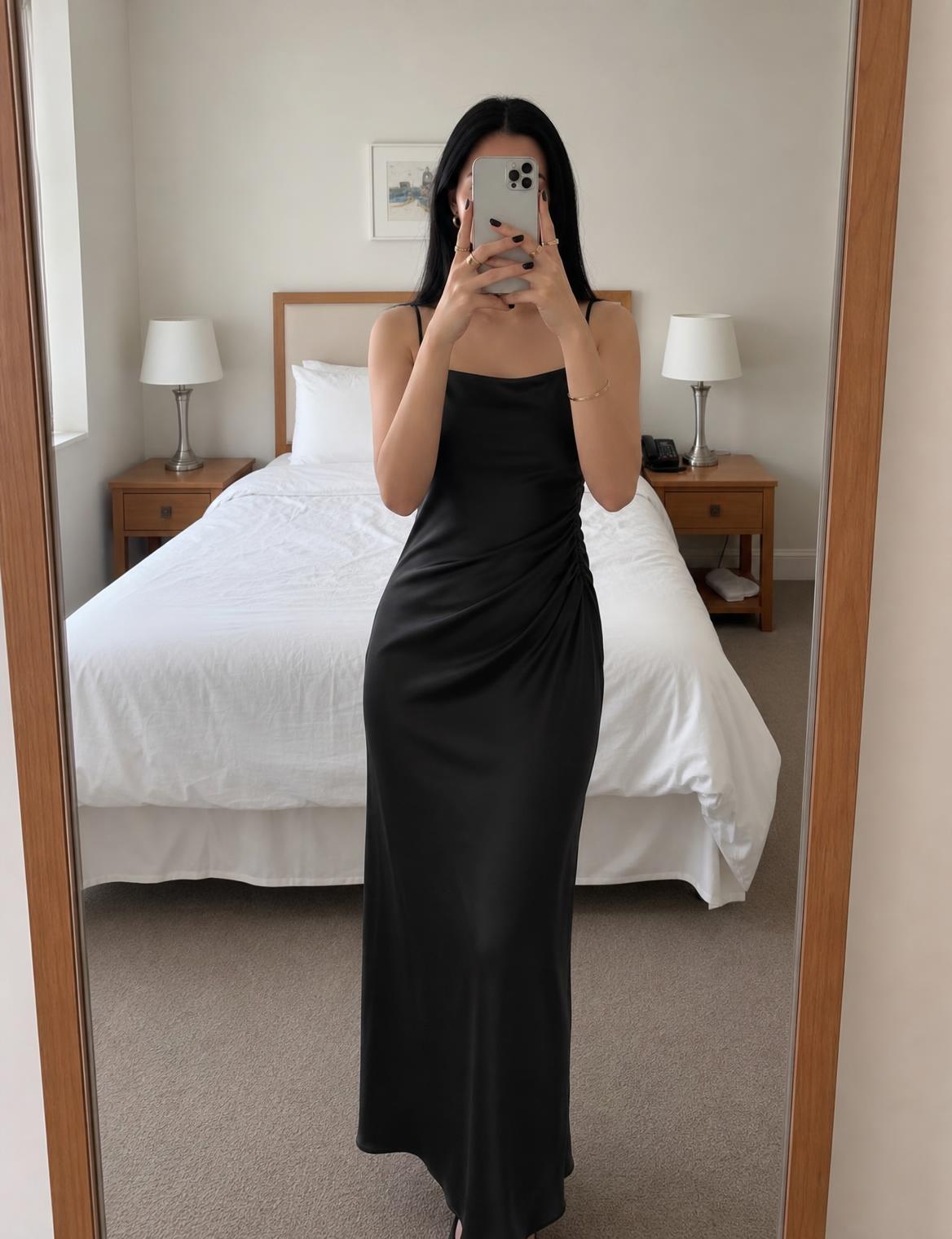 Black satin slip dress with ruched side and draped hem