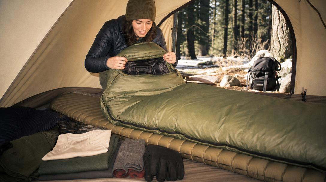 Camp sleeping setup showing sleeping bag, pad, and shelter