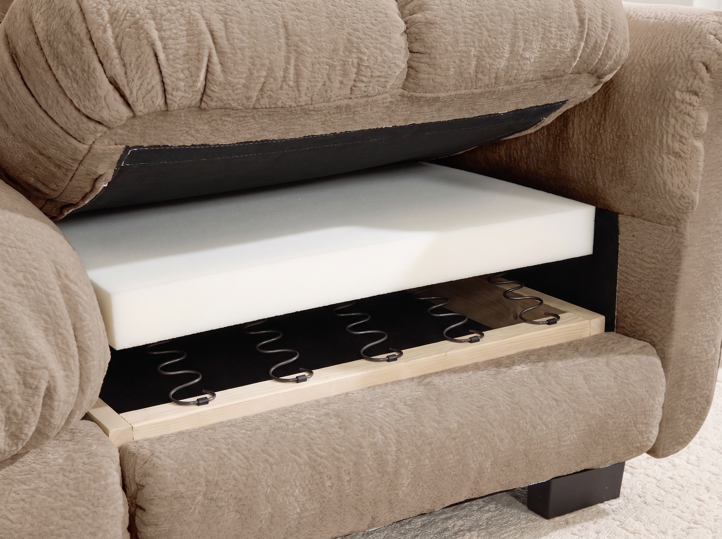 Seat cushion lifted to show high-density foam over spring support and the frame edge