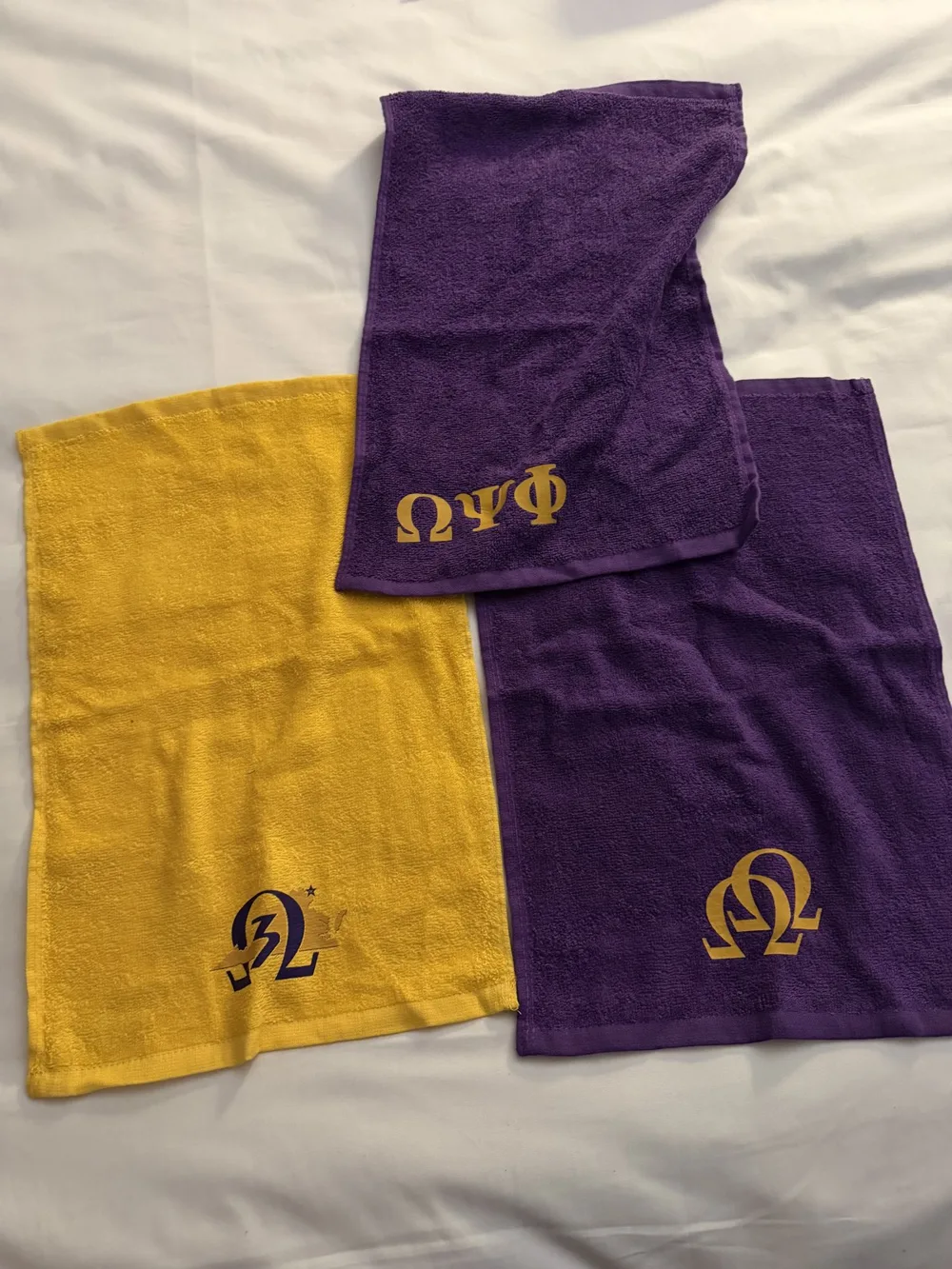 Purple and gold towels with embroidered Greek letters