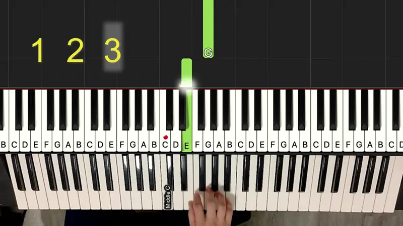 A still from the falling-keys video: a green note bar lands on the E key, with letter names on every key